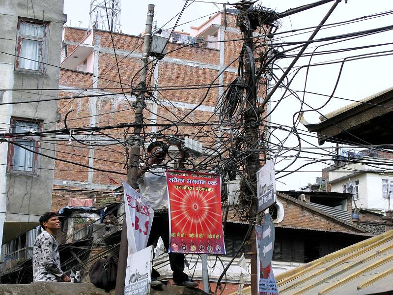 Gesehen in Kathmandu... Wer will da nicht gerne Elektriker sein? Taktik war folgende: Wenn man Strom brauchte, kletterte man einen Mast hoch, und suchte sich irgendwo ein freies Ende. Wenn man keins fand, machte man sich eins. Kathmandu hat brigends PRO TAG  im Schnitt 5 Stunden Stromausfall.